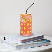 Load image into Gallery viewer, Glass with lemon design filled with pink lemonade on a stack of books
