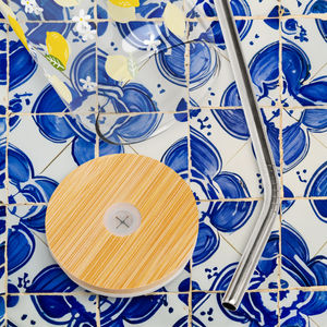 Glass with lemon design on top of blue and white Portuguese tiles