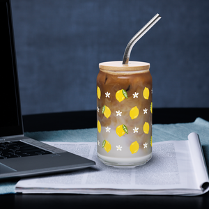 Glass with lemon design filled with iced coffee on a desk with a laptop