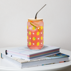 Glass with lemon design filled with pink lemonade on a stack of books